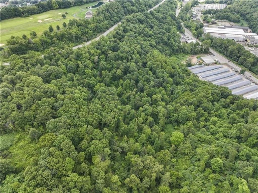 an aerial view of residential house with outdoor space and trees all around