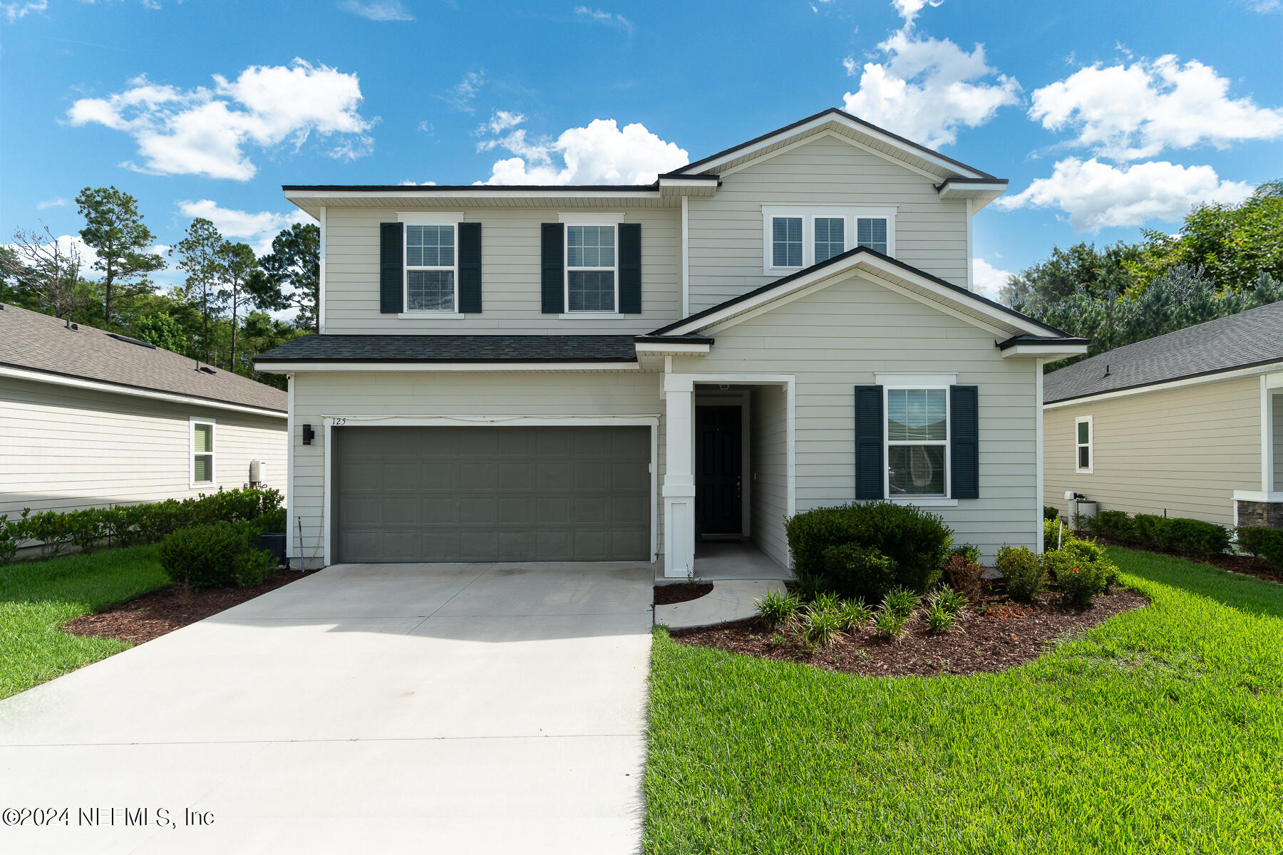 a front view of a house with a yard and garage