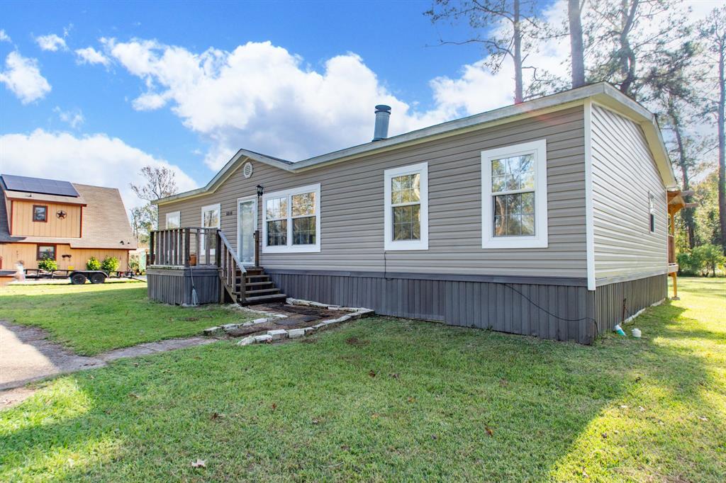 a view of a house with a yard and sitting area