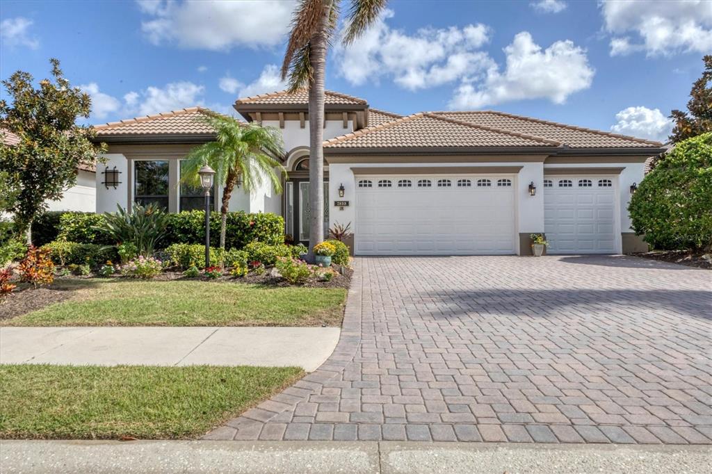 a front view of a house with a yard and potted plants