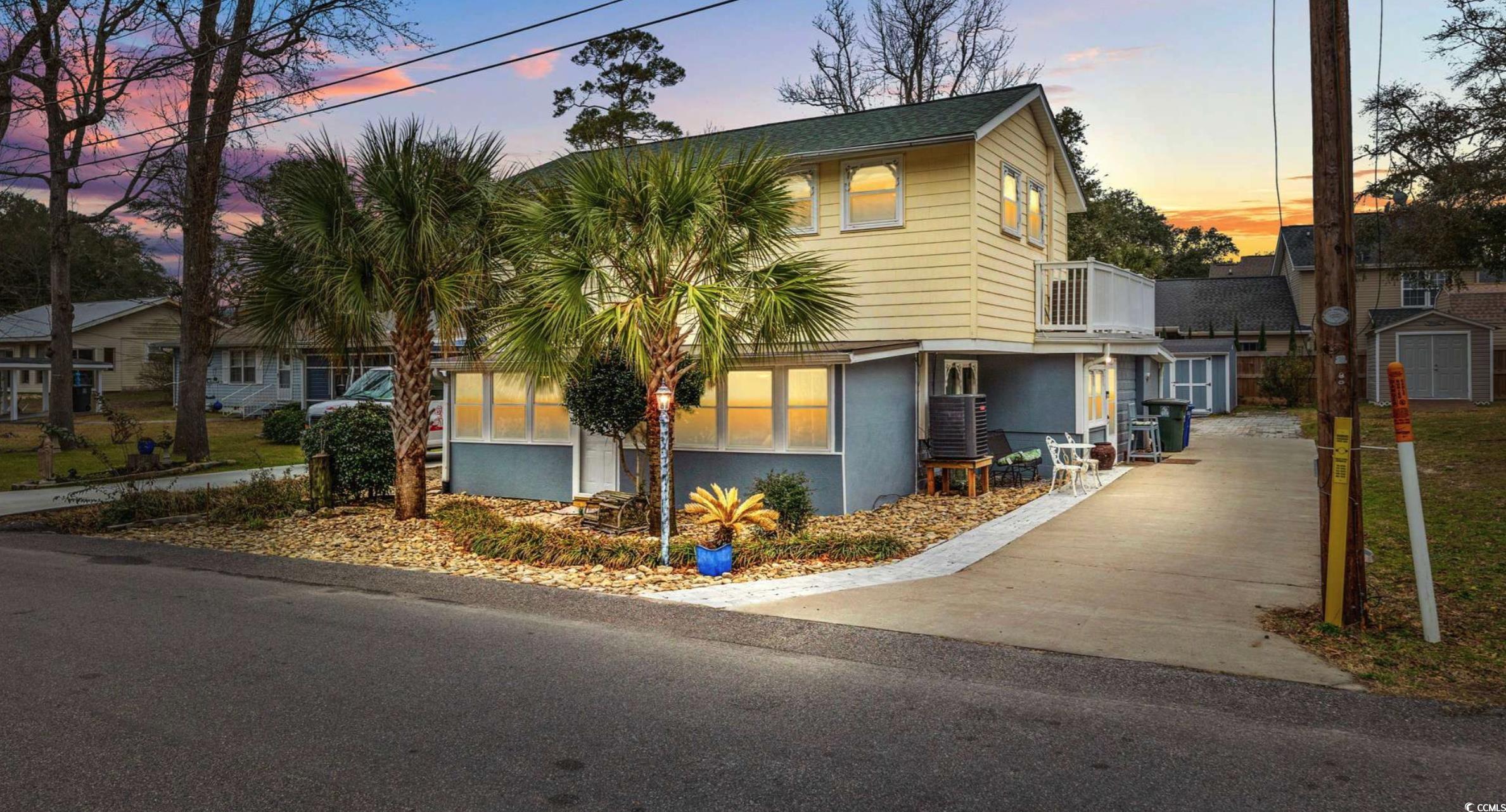 View of front of house with a shed and a balcony