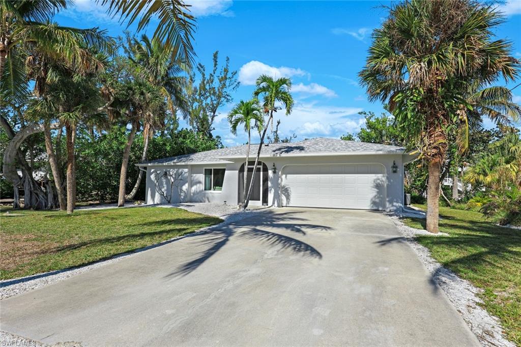 a view of a house with a yard and palm trees