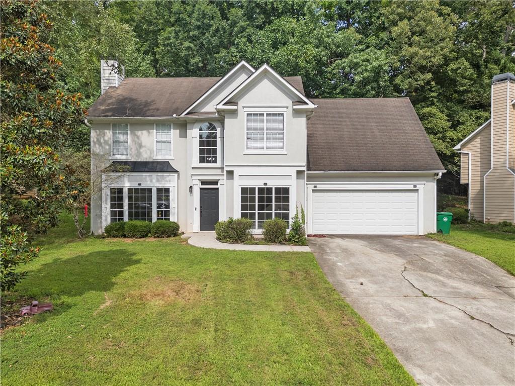 a front view of a house with a yard and garage