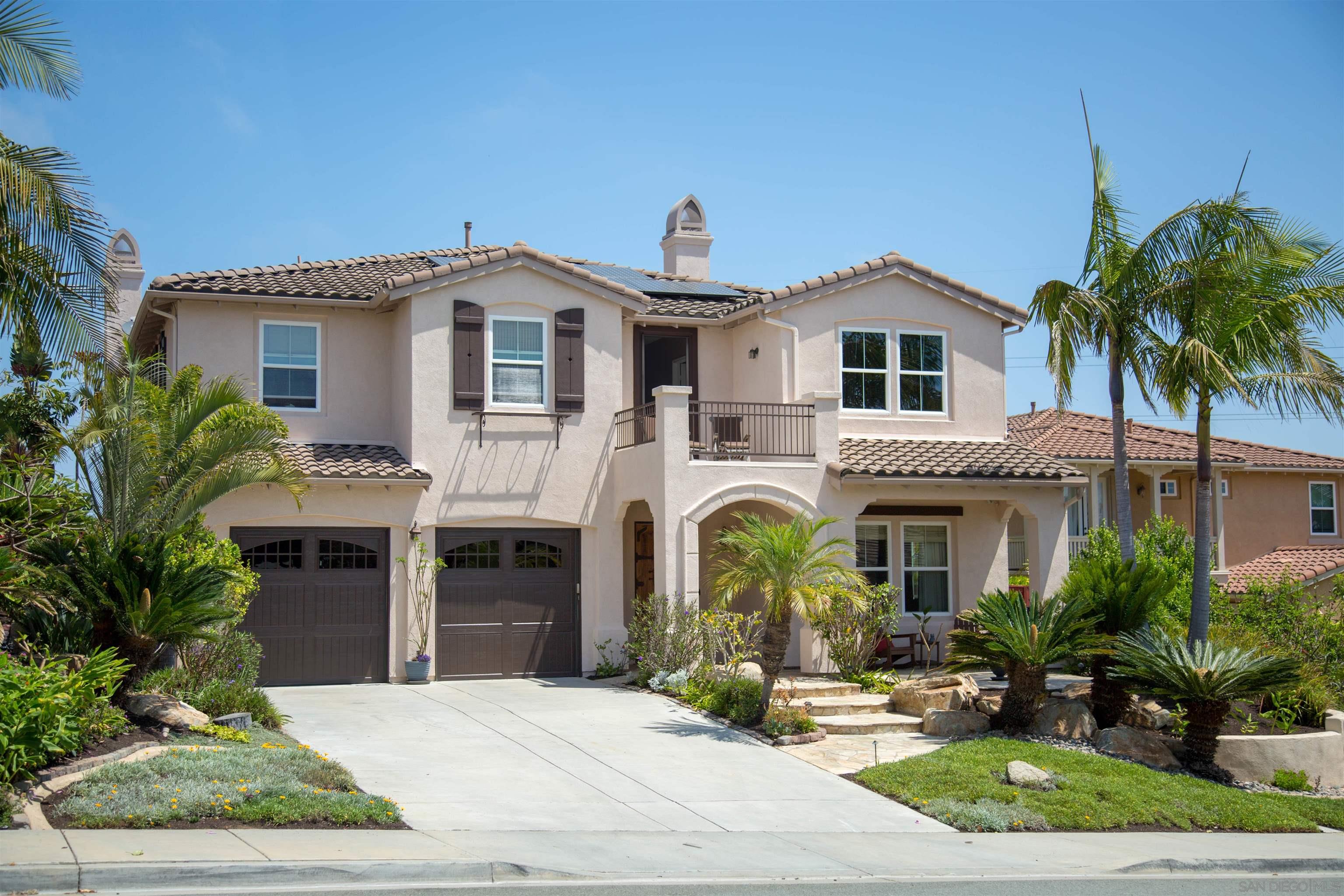 a front view of a house with yard and parking