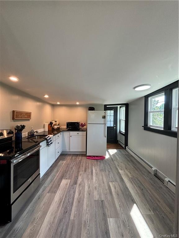 a large kitchen with wooden floors and stainless steel appliances