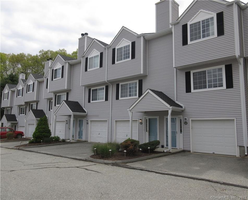 a front view of a house with yard and parking