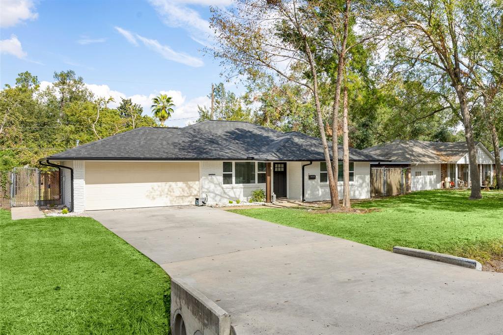 front view of a house with a yard and an trees