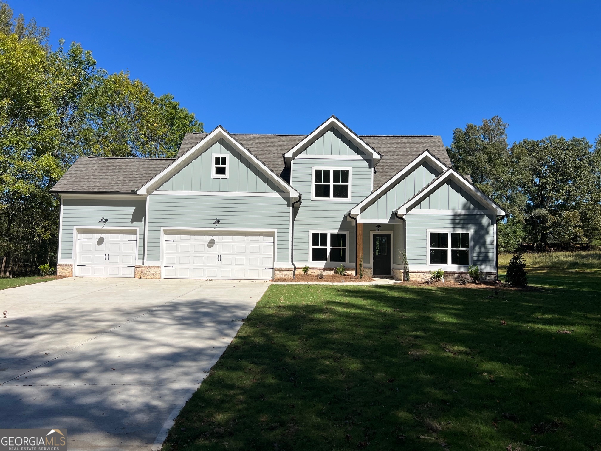 a front view of a house with a yard and trees