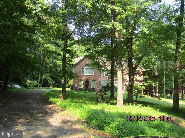 a view of backyard of house with green space