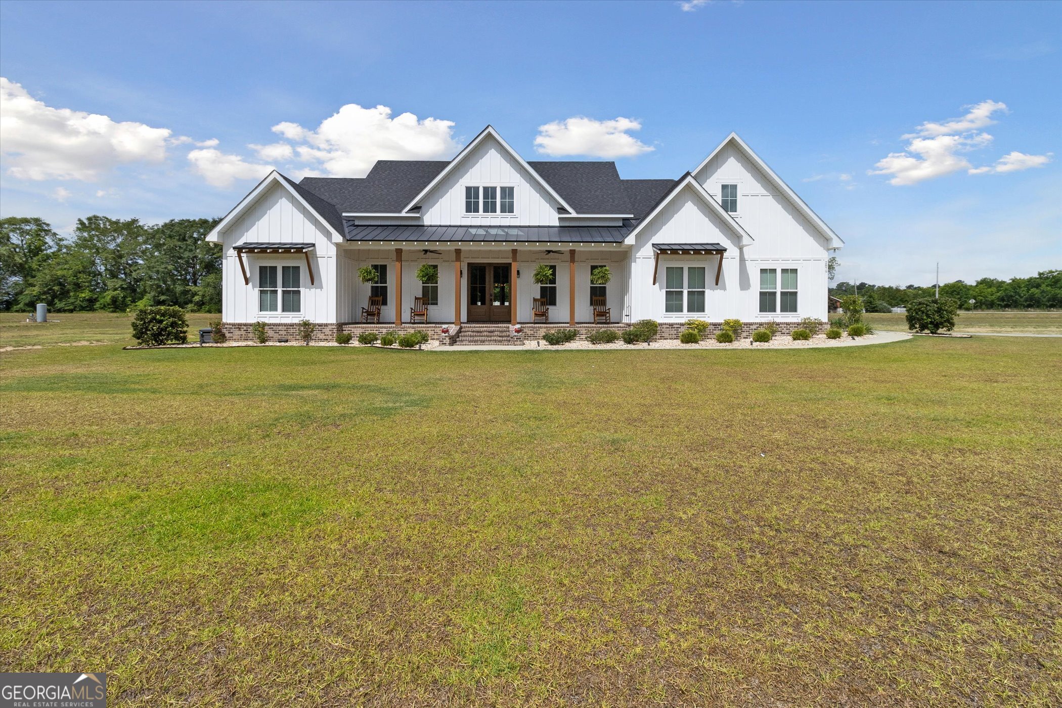 a front view of house with yard along with seating space