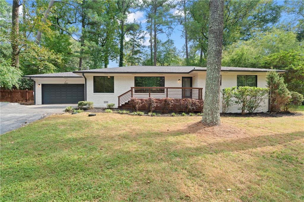 a view of a house with backyard and trees