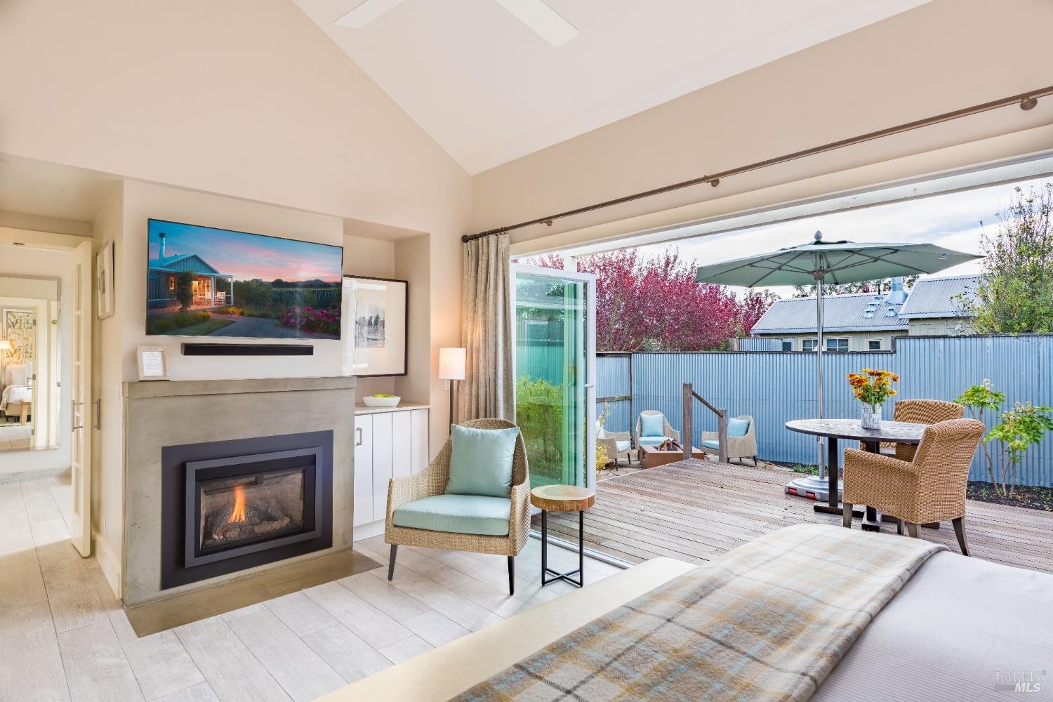 a living room with furniture a fireplace and a floor to ceiling window