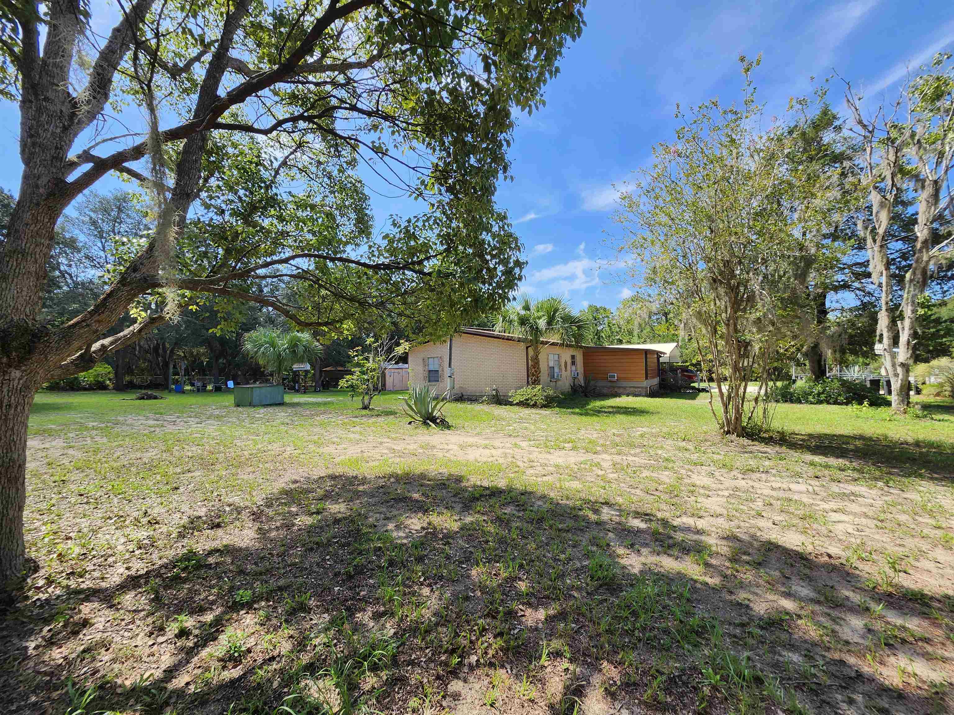 a front view of a house with a yard and trees