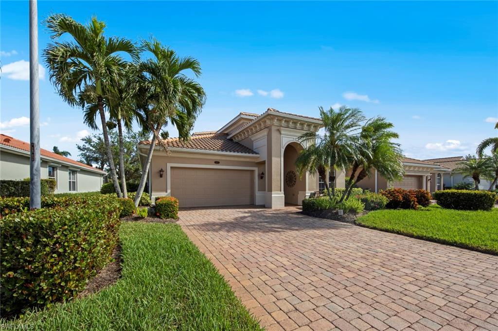 a view of a house with a yard and palm trees