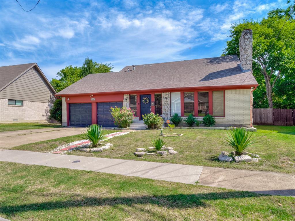 a front view of a house with a yard and potted plants