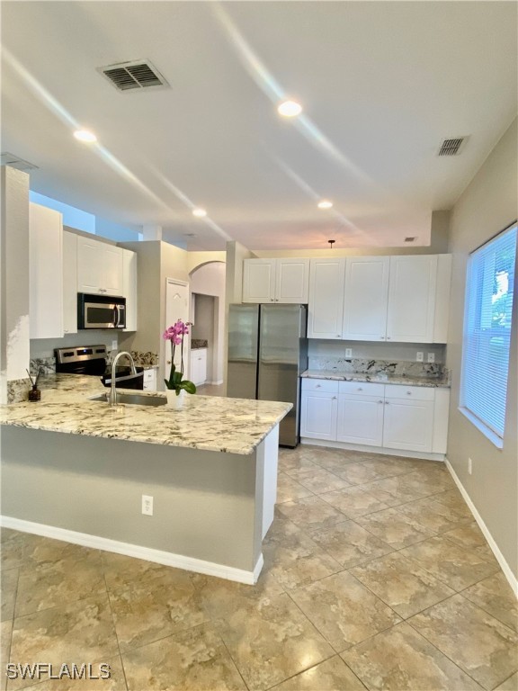 a view of a kitchen with kitchen island a counter top space a sink stainless steel appliances and cabinets