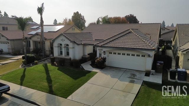 a view of a house with backyard and sitting area