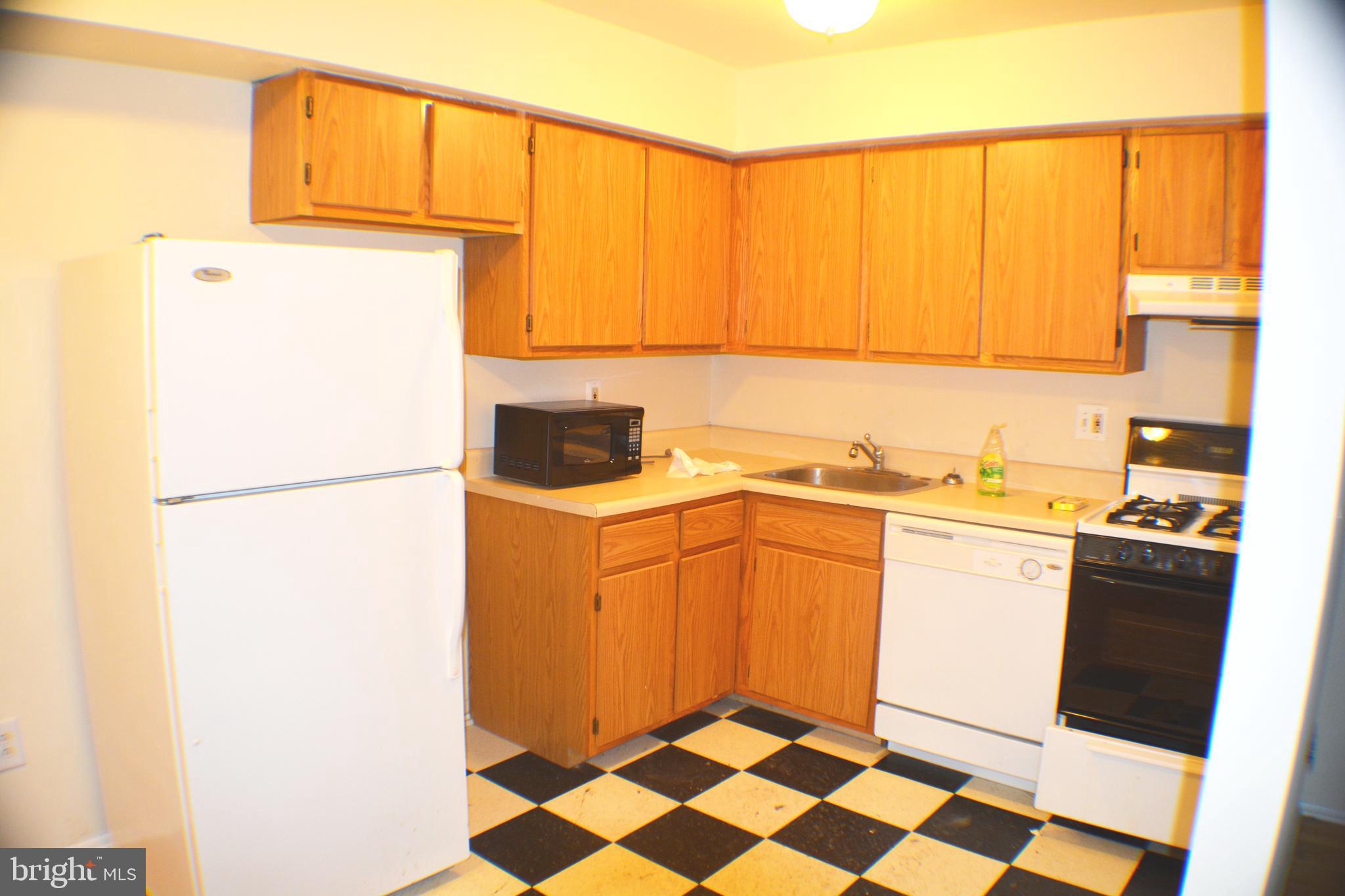 a kitchen with a sink a refrigerator and cabinets