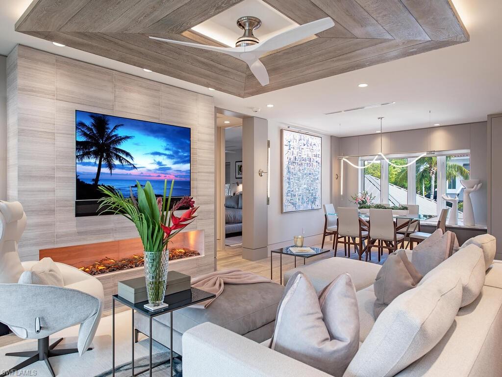 Spacious living space with cloud ceiling, Legno Bastone floors, and tiled fireplace