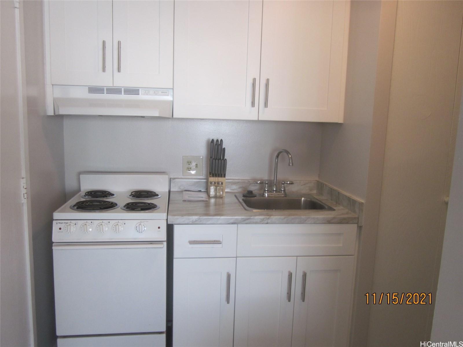 a kitchen with granite countertop white cabinets and a stove