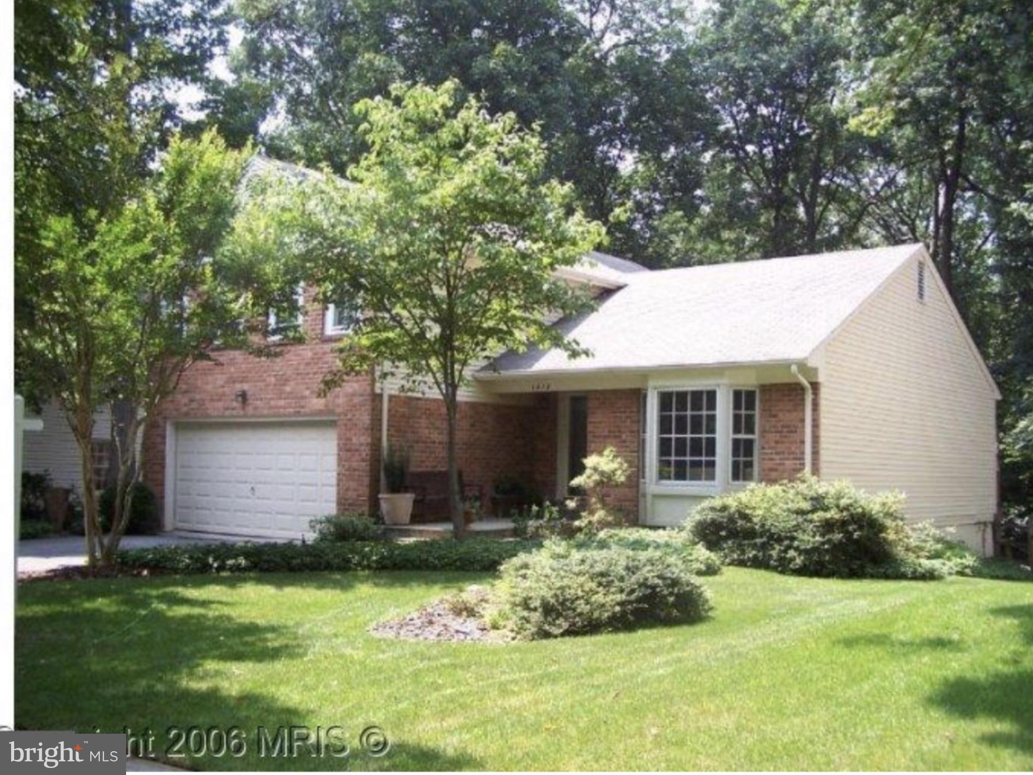 a view of house with a yard and potted plants