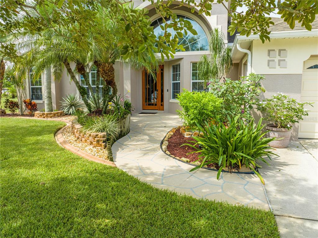 a view of a white house with a big yard and potted plants