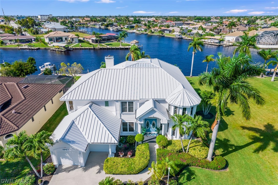 an aerial view of a house with a garden and lake view