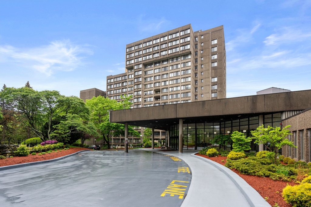 a view of a tall building with a yard and sitting area