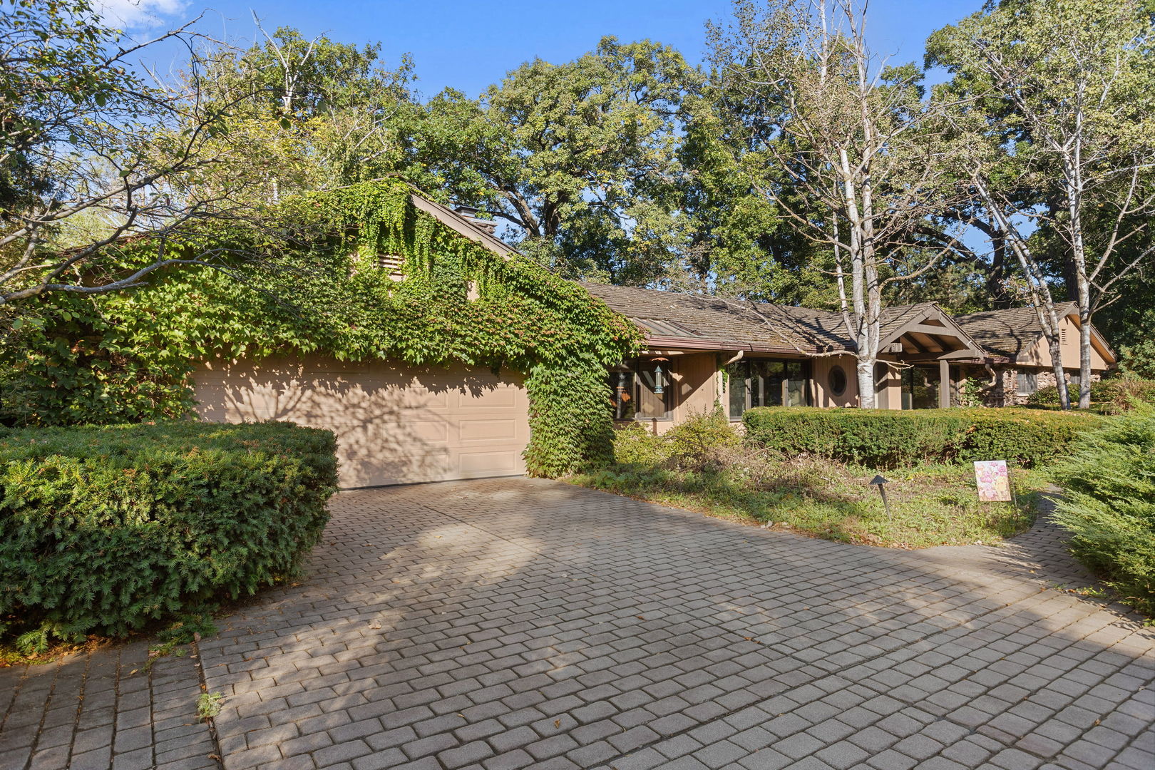 a front view of a house with a yard and a garden