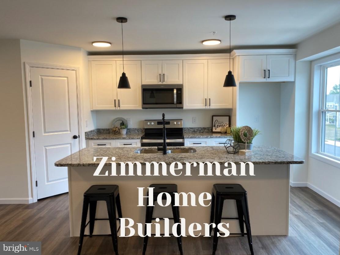 a kitchen with granite countertop a stove a sink and a refrigerator