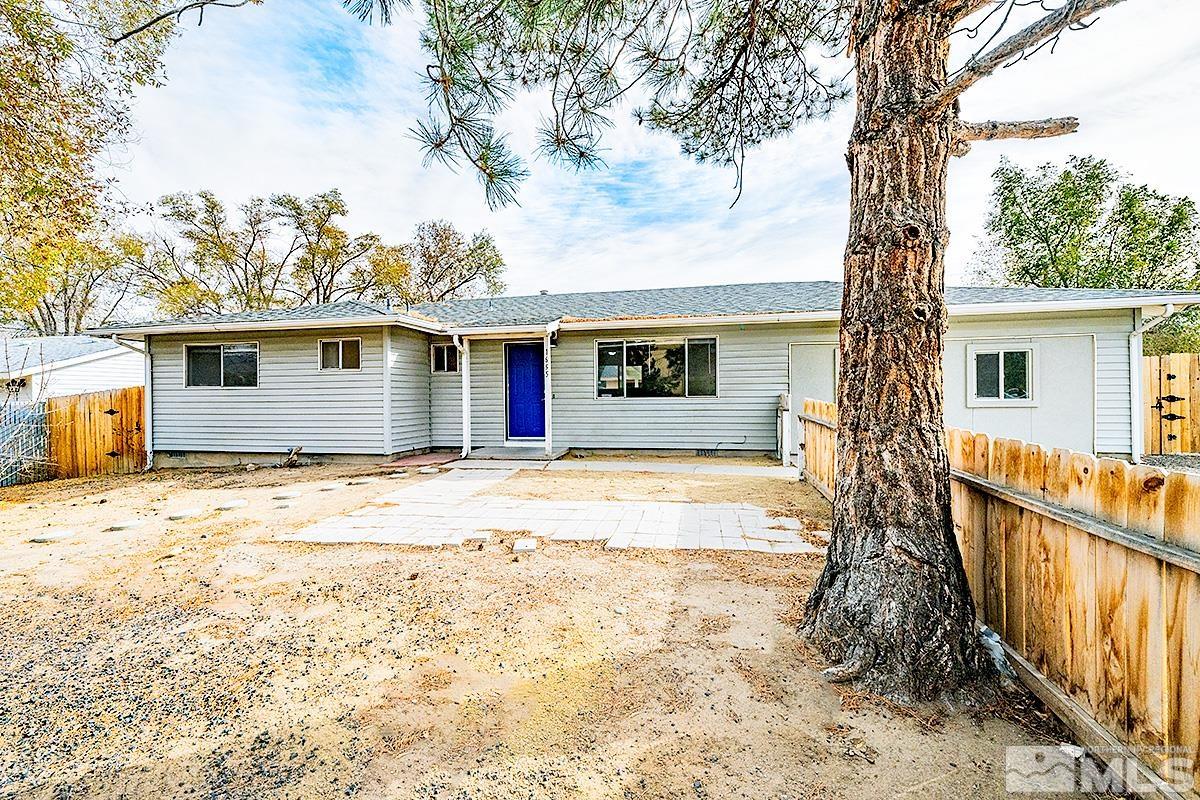 a view of a house with wooden fence and a tree