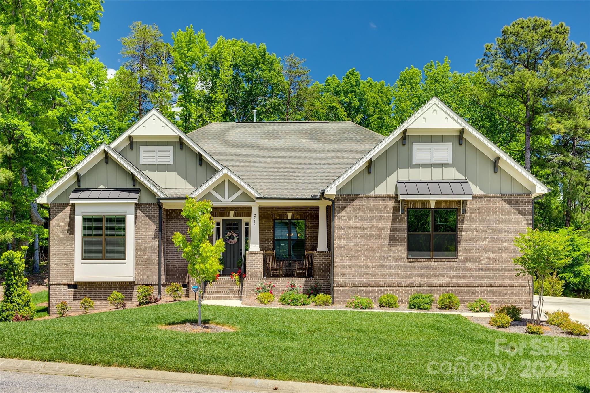 a front view of a house with a yard and green space