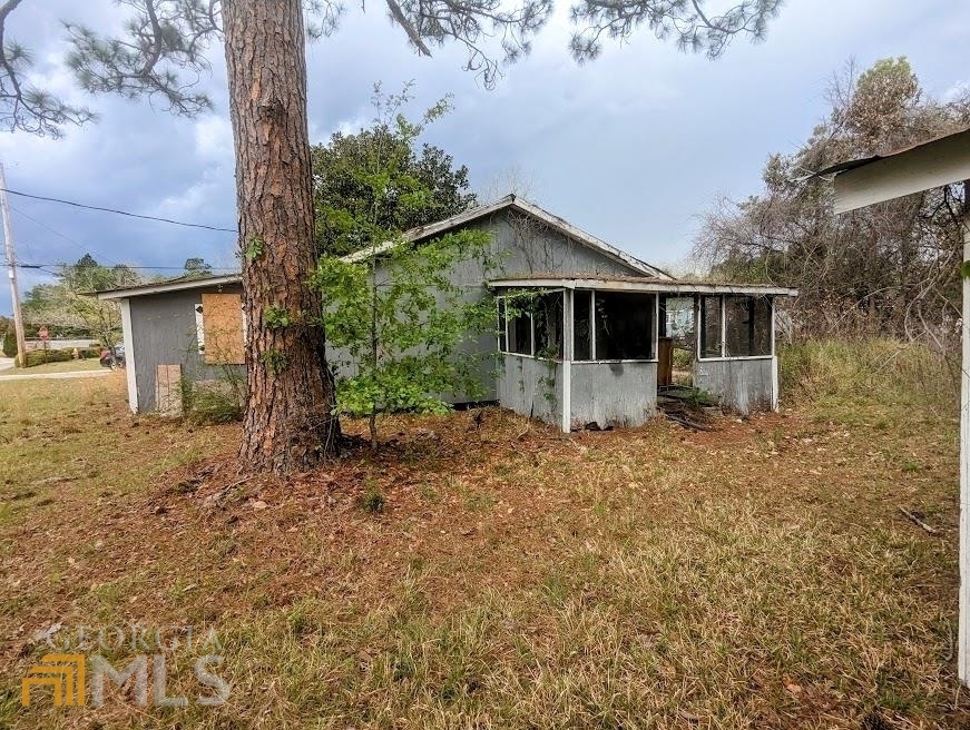 a front view of house with yard and trees around