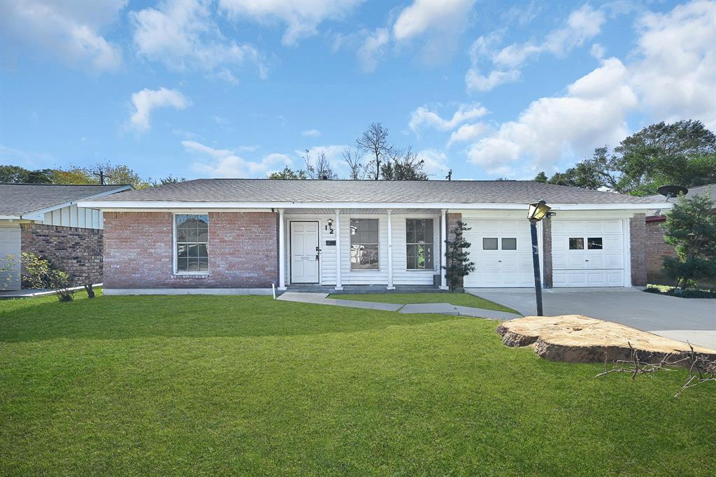 a front view of a house with a garden and yard