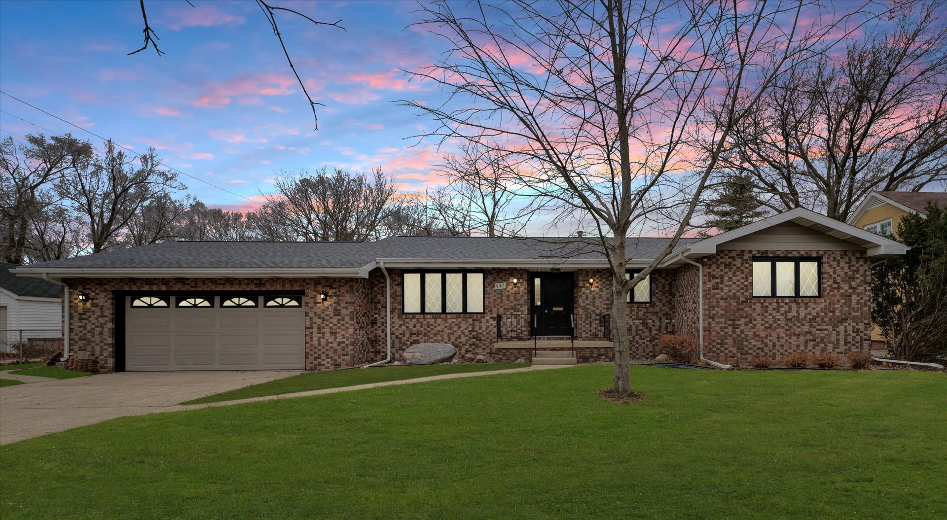 a front view of a house with a garden and yard