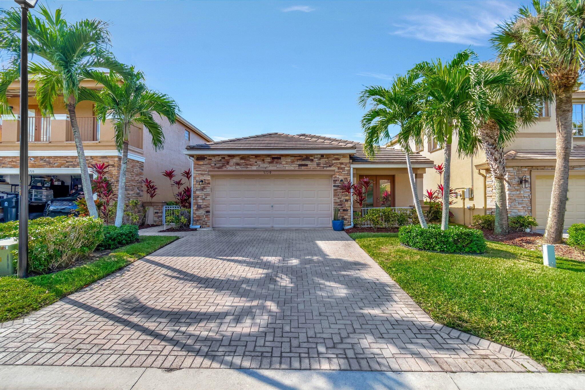 a front view of a house with a yard and a garage