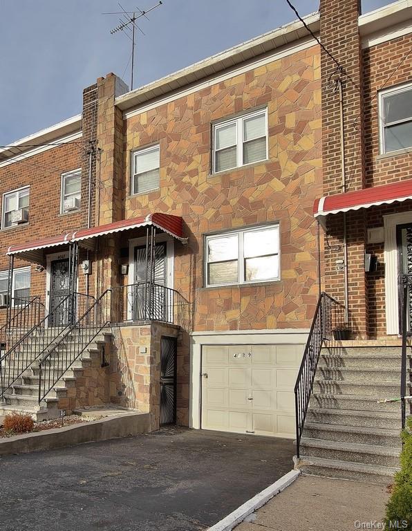 Townhome / multi-family property featuring a garage and cooling unit