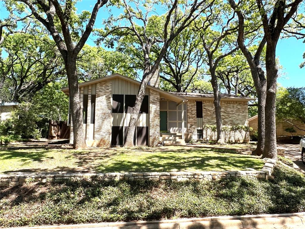 a front view of a house with a tree