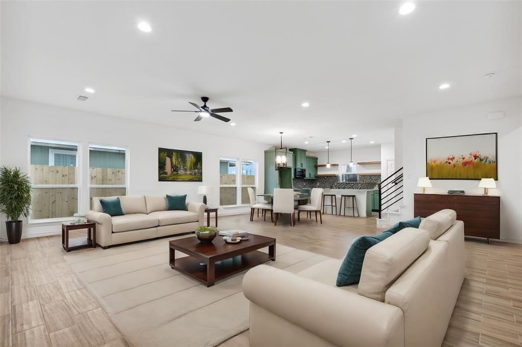 a living room with furniture kitchen view and a large window