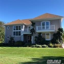 View of front of property featuring a balcony and a front lawn