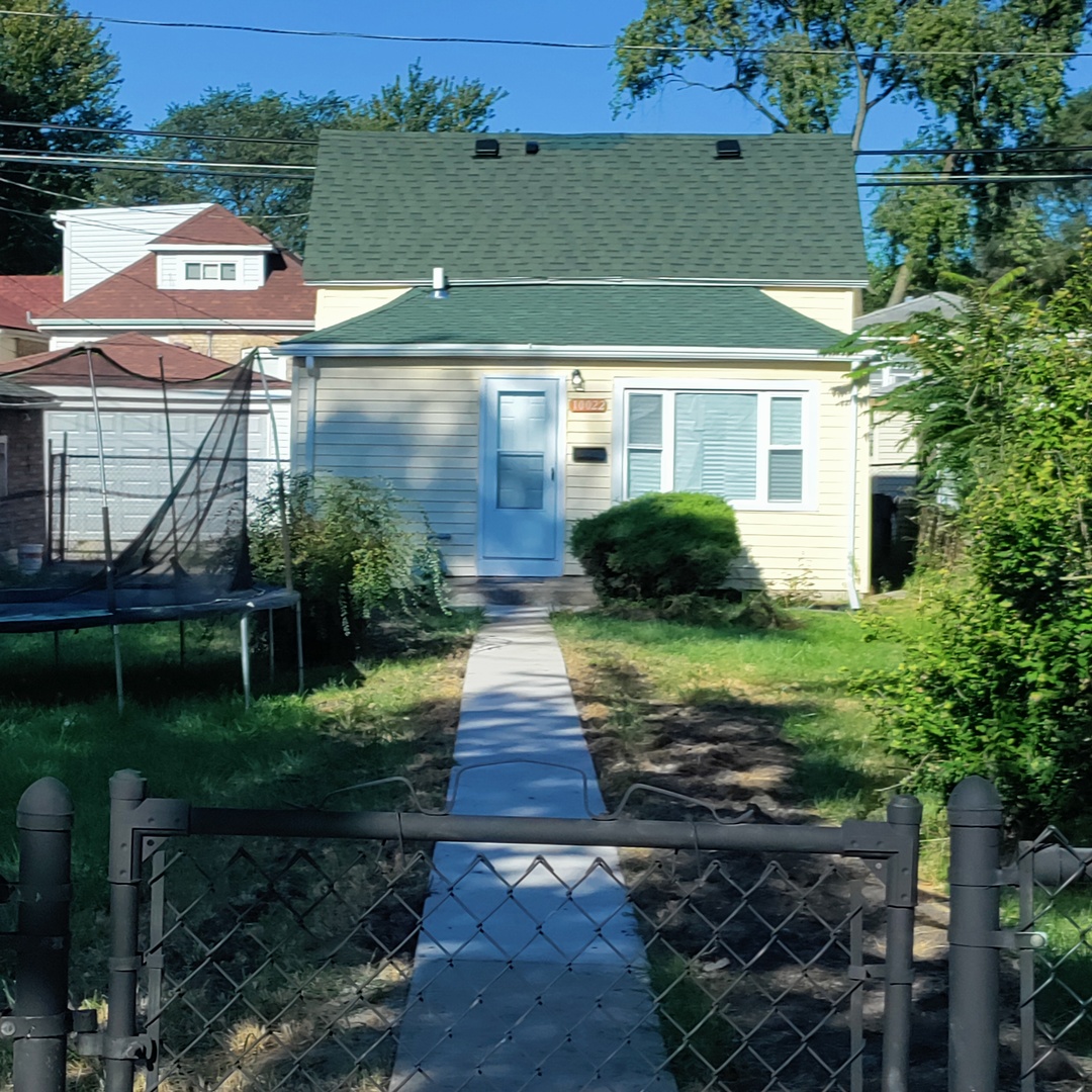 a view of a yard in front of a house with a fountain