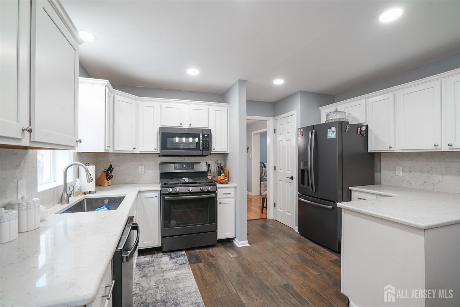 a kitchen with stainless steel appliances granite countertop a refrigerator sink and stove