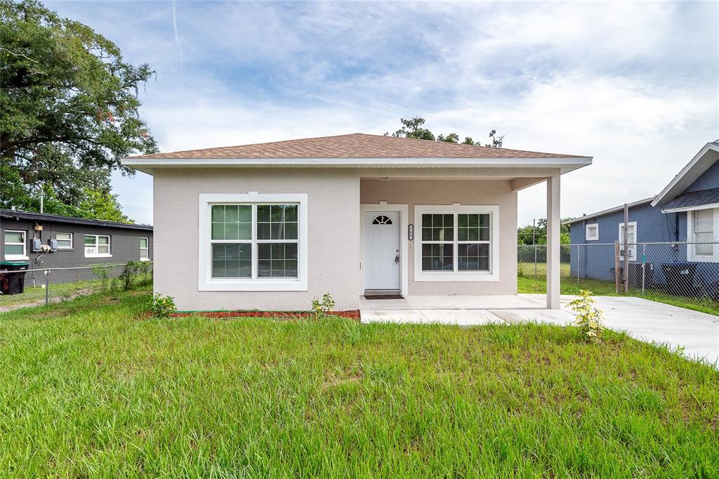 a view of a house with a yard and sitting area