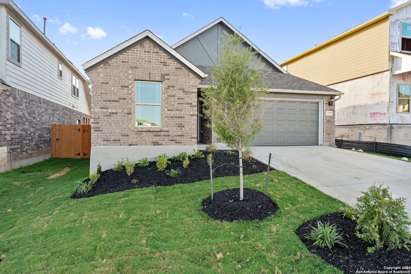 a front view of a house with garden and plants