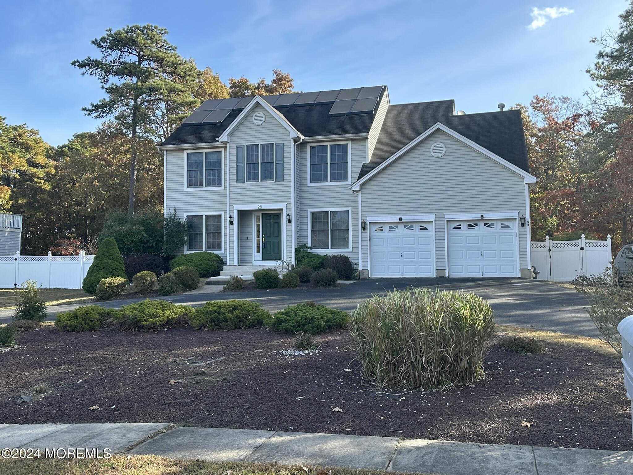 a view of a big house with a yard and plants