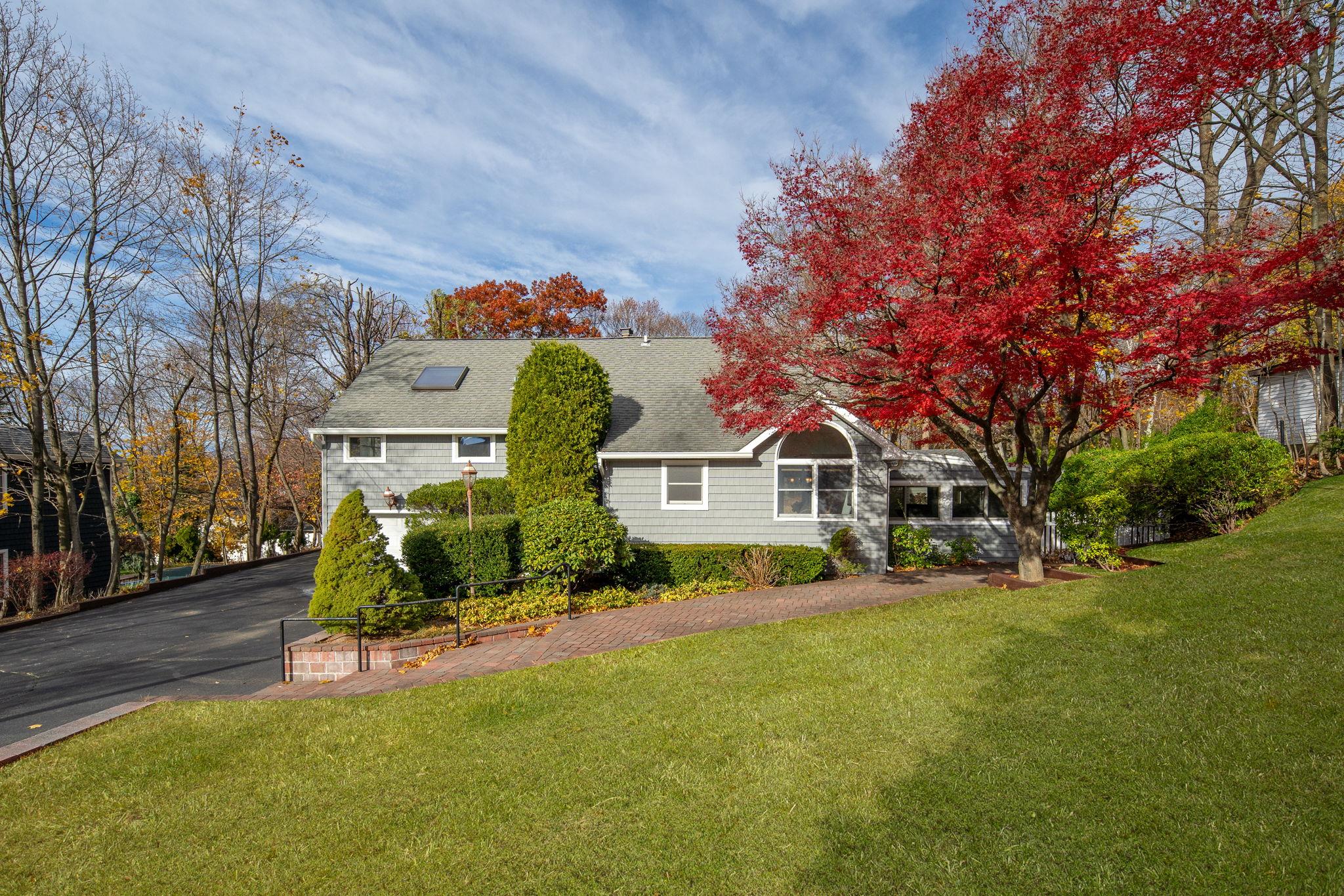 a view of a house with a big yard and large trees