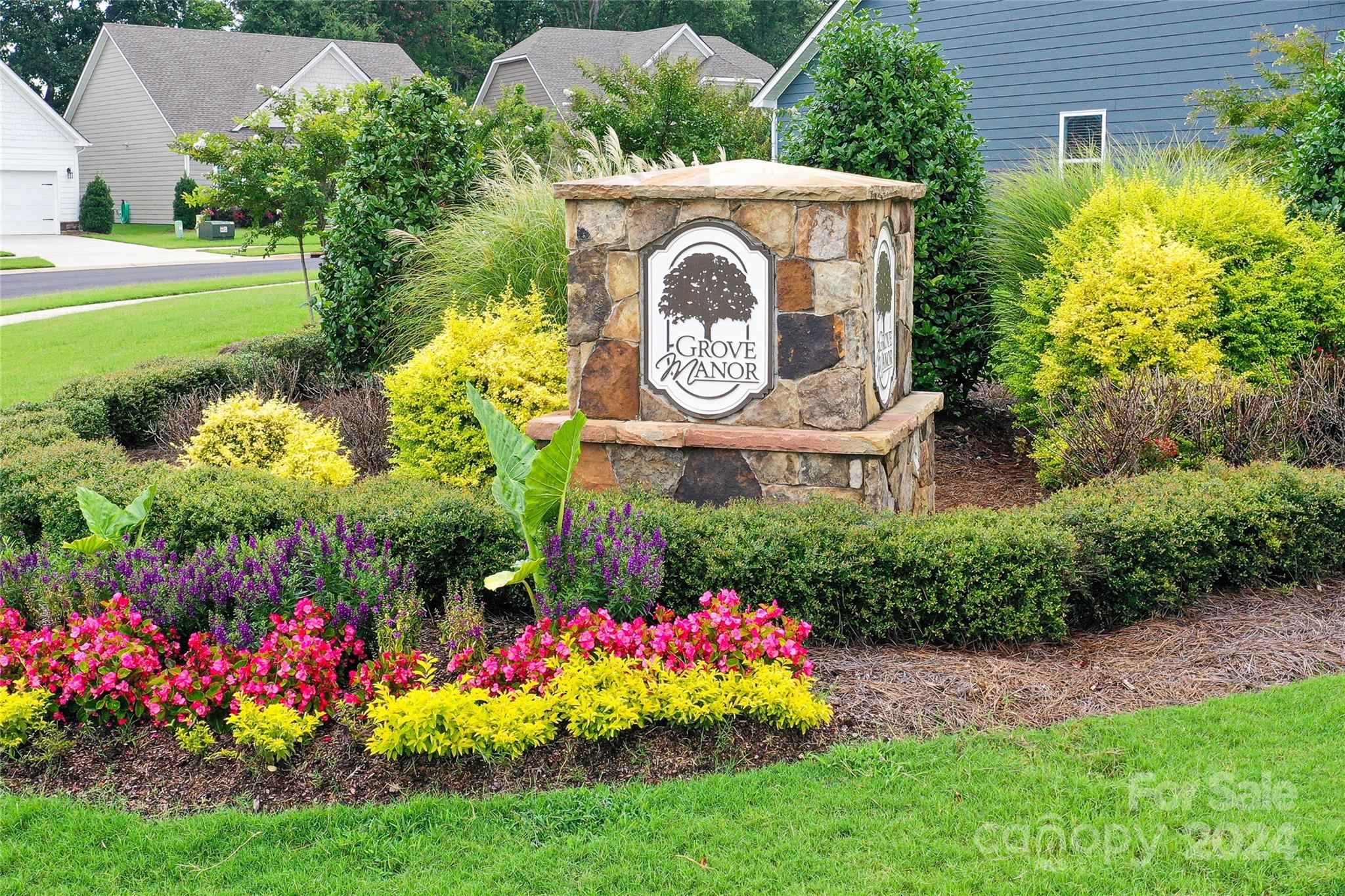 a view of a sign board with garden in the background