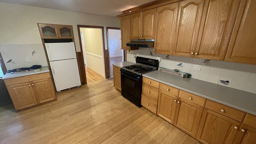 a kitchen with stainless steel appliances a refrigerator stove and wooden cabinets