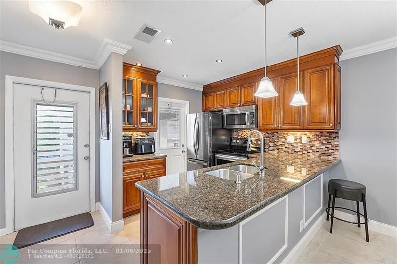 a kitchen with stainless steel appliances granite countertop a sink a stove and a refrigerator