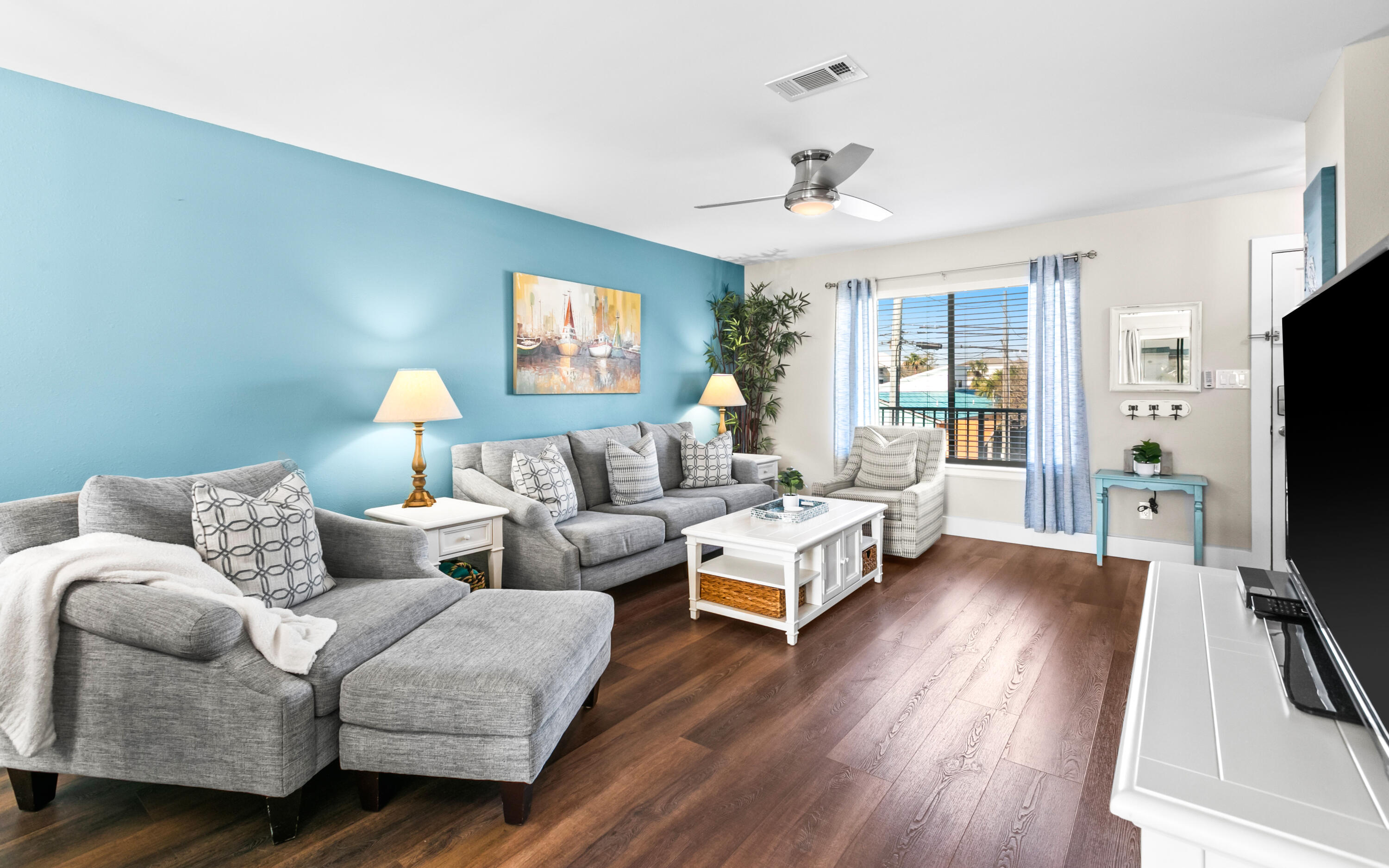 a living room with furniture flat screen tv and wooden floor